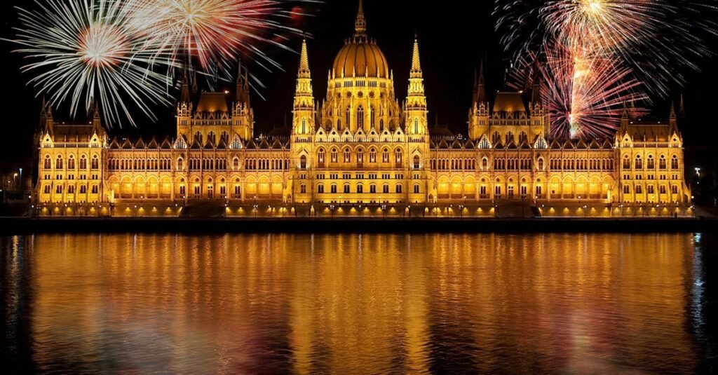 The Best Relocation Checklist for Moving to Budapest in 2025 Vibrant fireworks illuminate the Hungarian Parliament Building in Budapest, reflecting over the Danube River.