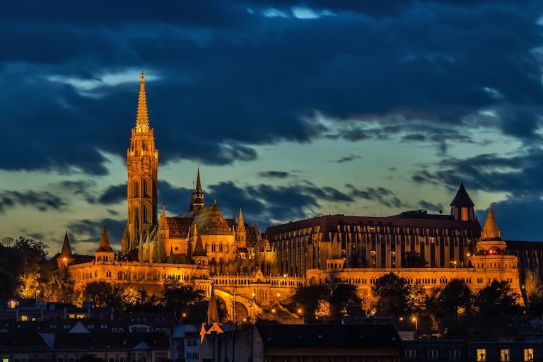 Captivating view of Matthias Church lit up at night in Budapest, Hungary. A stunning architectural marvel. Budapest safety