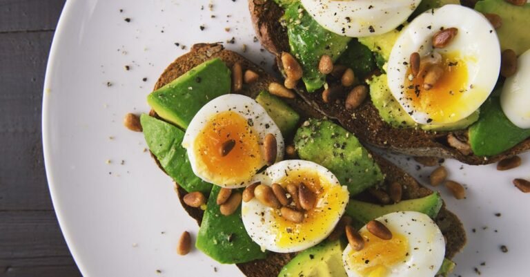 Food in Budapest: Must-Try Places Every Expat Needs to Know Delicious avocado toast topped with soft-boiled eggs and pine nuts on a white plate. vegetarian food in budapest